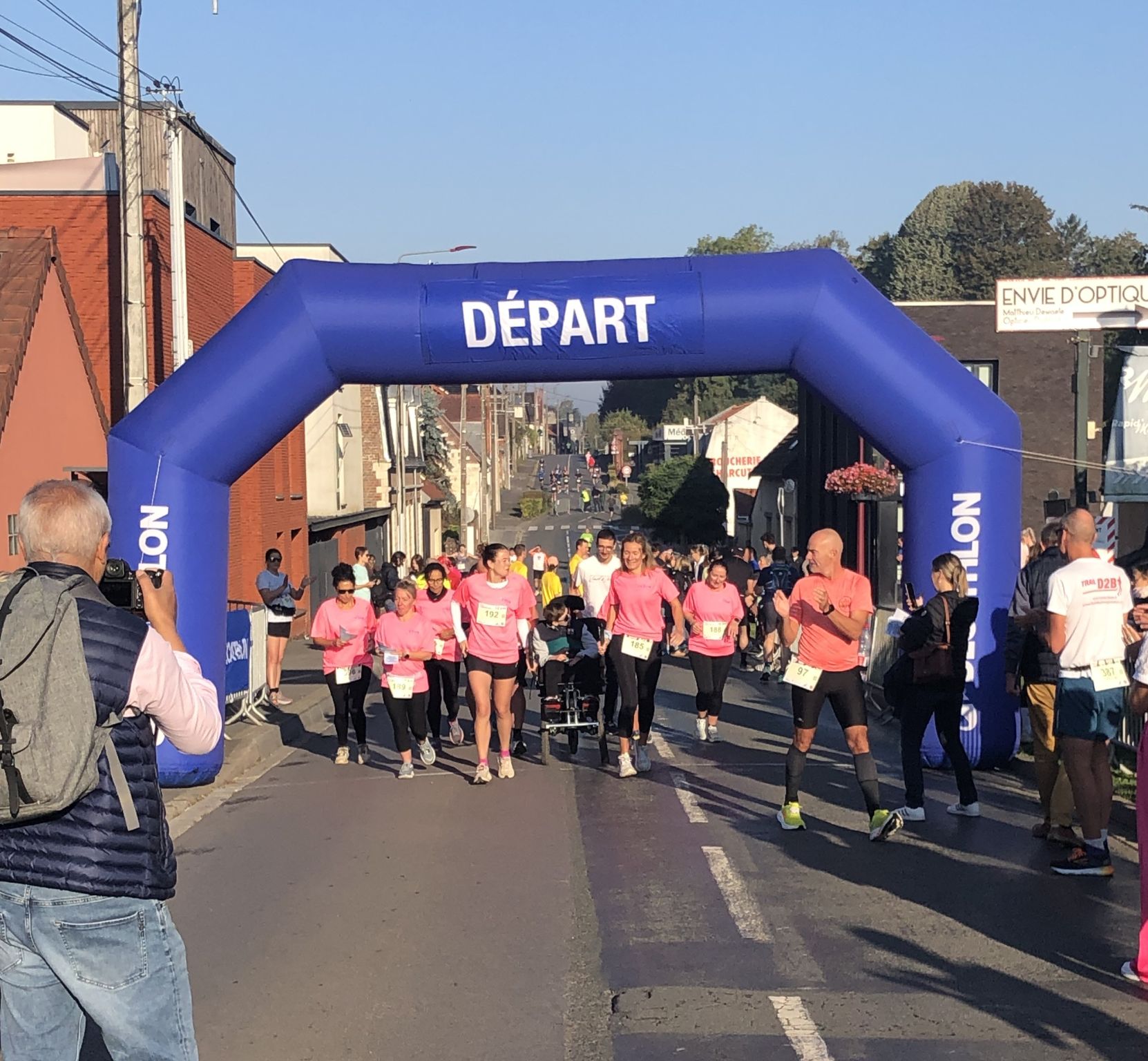 Départ d’une course : coureurs et jeune en fauteuil sur vélo pousseur